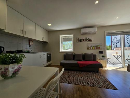 cocina y sala de estar con sofá en Fascinante Orbita Apartments, en Vila Nova de Famalicão