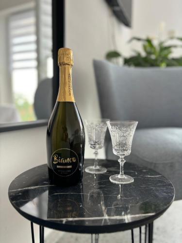 a bottle of wine on a table with two glasses at Ema Rooms in Novi Vinodolski