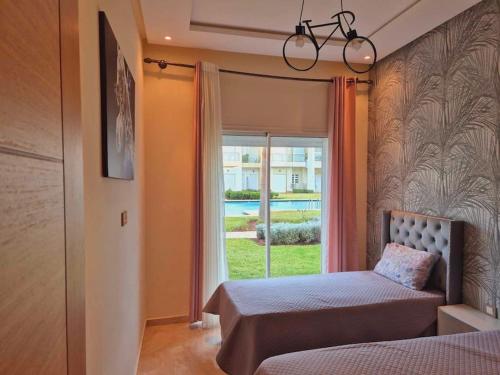 a bedroom with a bed and a window at CASA BAY BEACH OMK 3 in Sidi Rahal