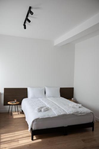 a white bedroom with a bed with white sheets at STUDIO APARTMANI IZVOR in Blagaj