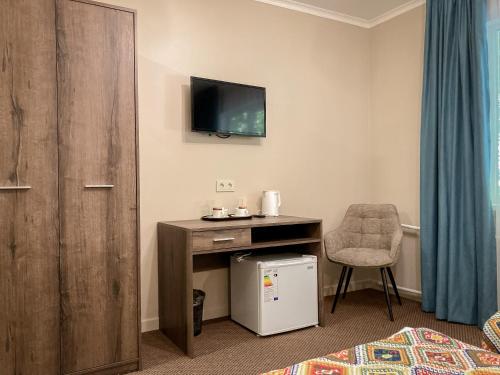 a room with a desk and a tv and a chair at Silk Way in Almaty