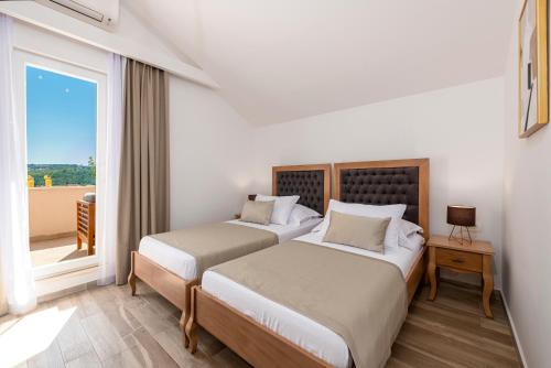 2 Betten in einem Zimmer mit Fenster in der Unterkunft Luxury Vila Divina-Exceptional privacy in Mlini