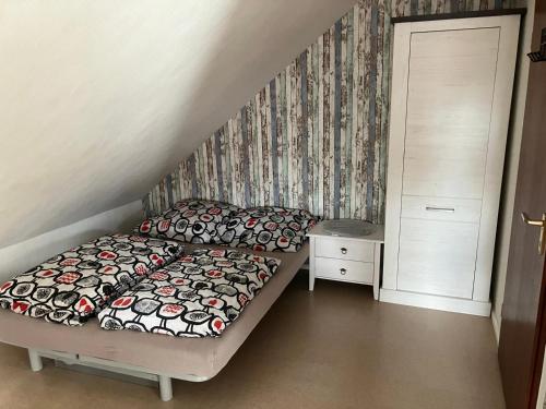 Habitación pequeña con cama y mesita de noche en Ferienzimmer-Wohnung in der Nähe von Hamburg mit eigener Küche und eigenem Bad mit Dusche, en Horst
