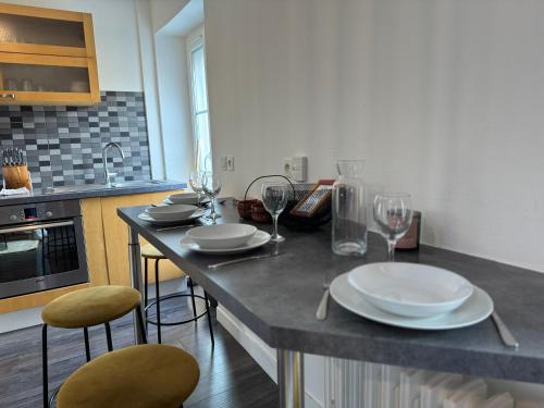 a kitchen with a table with plates and wine glasses at Terracotta - 5 pers - hyper centre - Rêve au Mans in Le Mans