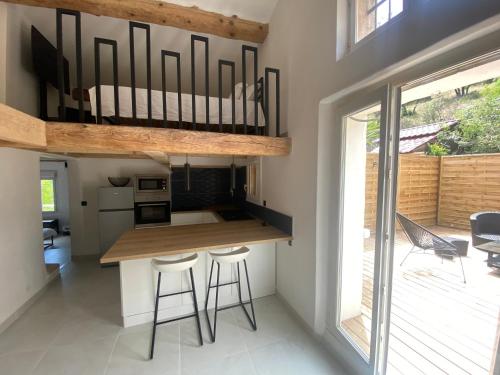 une cuisine avec un comptoir et des tabourets dans une maison dans l'établissement Appartement entièrement rénové à Saint-Aygulf, à Fréjus