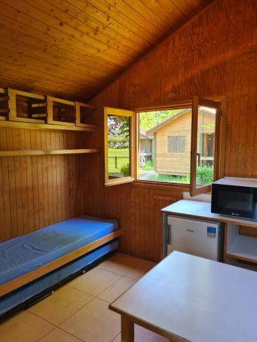 Cette petite chambre comprend des lits superposés et une table. dans l'établissement Les Chalets Guinguette, à Capdenac-Gare