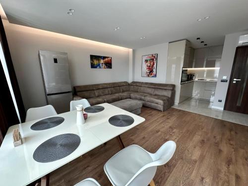 Pernik的住宿－Apartment G17，客厅配有白色的桌子和白色的椅子
