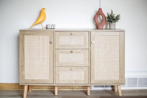 a wooden cabinet with three drawers and a vase at Gridiron Getaway-Where Families and Fans Unite in Canton