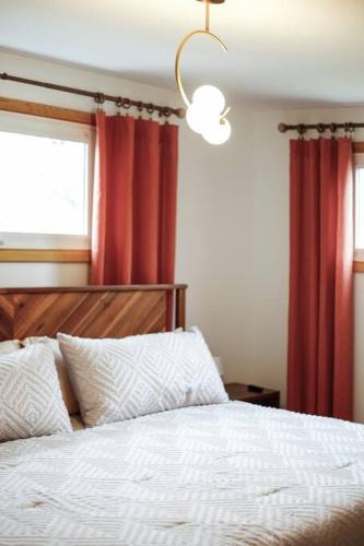 a bedroom with a white bed with red curtains at Gridiron Getaway-Where Families and Fans Unite in Canton