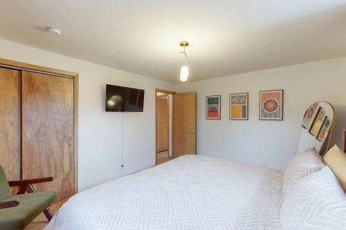 a bedroom with a large white bed and a television at Gridiron Getaway-Where Families and Fans Unite in Canton