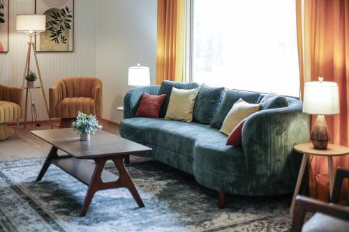 a living room with a green couch and a table at Gridiron Getaway-Where Families and Fans Unite in Canton