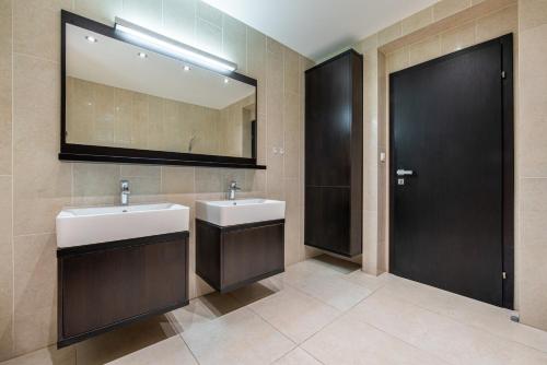 a bathroom with two sinks and a mirror at Chillgarden Apartments in Trenčín