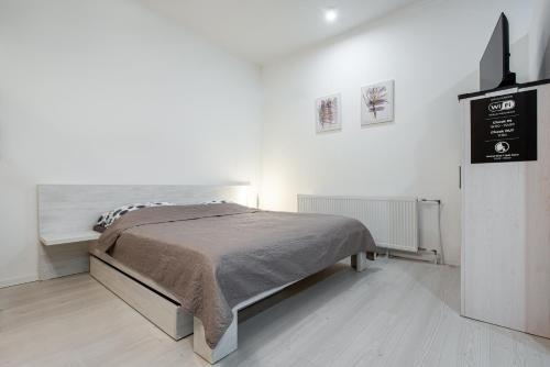 a bedroom with a bed in a white room at Chillgarden Apartments in Trenčín