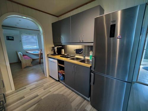 a kitchen with a stainless steel refrigerator in a room at House in the heart of the Lyngen Alps with Best view in Lyngseidet
