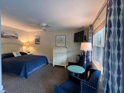 a bedroom with a bed and a chair and a table at Island Place in Bar Harbor