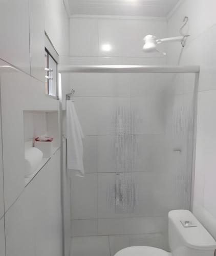 a white bathroom with a shower and a toilet at Apto n.09 condominio custo beneficio. in Brasília