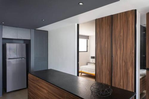 a kitchen with a black counter top and a refrigerator at Downtown modern apartment Unique location in Playa del Carmen