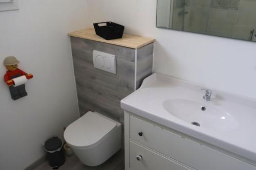 a bathroom with a white toilet and a sink at Au Clair matin sur l'Yères in Sept-Meules
