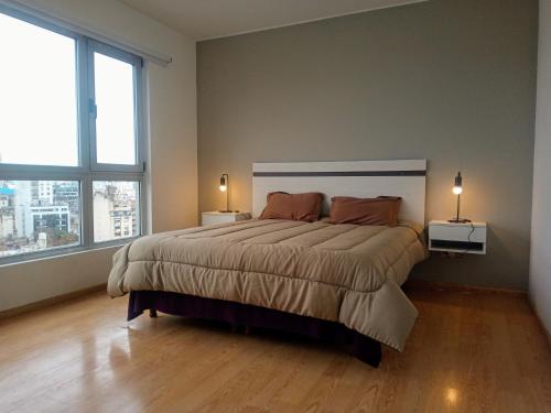 a bedroom with a large bed and two windows at Quartier San Telmo Luxury Pool Gym & Spa, piscina climatizada in Buenos Aires
