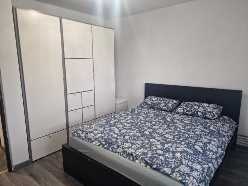 a bedroom with a bed with blue and white sheets at Apartament Gara de Nord in Bucharest