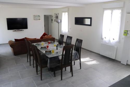 a dining room with a table and chairs at Au Clair matin sur l'Yères in Sept-Meules