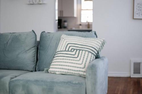 a pillow on a blue couch in a living room at End Zone Escape-Light and Bright HOF Village Home in Canton