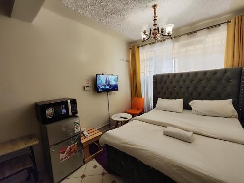 KikuyuSoft Life Crib in Kinoo with Wifi & Netflix的一间带大床和电视的卧室