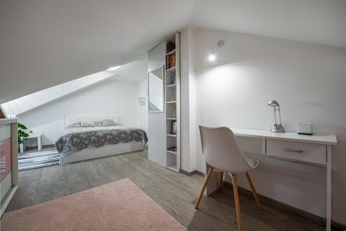 a bedroom with a bed and a desk with a chair at Chillgarden Apartments in Trenčín