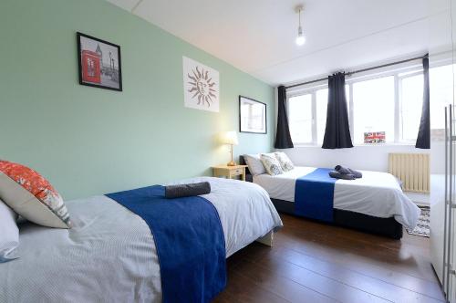 a bedroom with two beds and a window at 3 BEDROOM FLAT IN CENTRAL LONDON - REGENTS PARK / BAKER ST in London