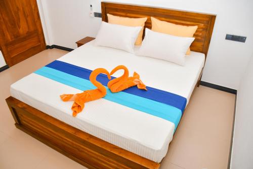 a bed with two orange swans on it at Ocean Grace in Arugam Bay