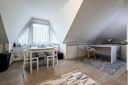 ein Esszimmer mit einem Tisch und einem Schreibtisch in der Unterkunft Chillgarden Apartments in Trenčín