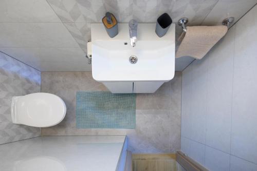 a bathroom with a white sink and a toilet at Apartment Maya in Podstrana