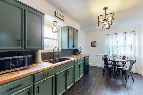 a kitchen with green cabinets and a table with chairs at Home Champions-HOF Village Comfort in Canton