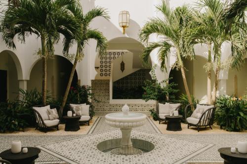 a lobby with palm trees and a fountain at Cap Juluca, A Belmond Hotel, Anguilla in West End Village
