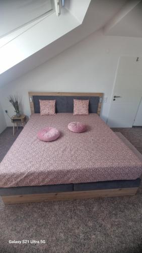 a bedroom with a bed with pink pillows on it at Ferienwohnung Seerandweg in Simmerath