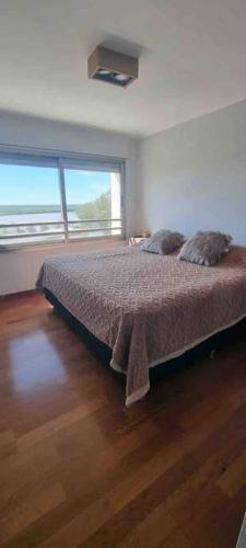 a bedroom with a bed and a large window at Ushuaia 1 in Rosario