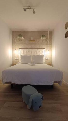 a bedroom with a large white bed with a elephant foot stool at Apartamento MARIANTO in Vejer de la Frontera