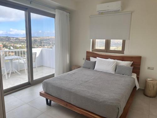a bedroom with a bed with a view of a balcony at Villa Olia in Pitsidia