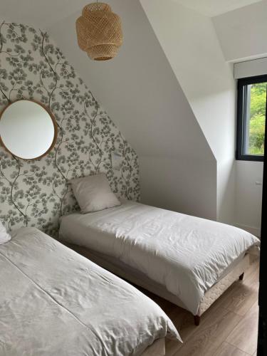 1 Schlafzimmer mit 2 Betten und einem Wandspiegel in der Unterkunft La chapelle in Fervaches