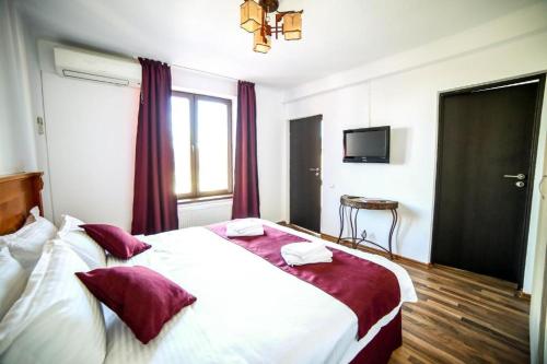 a bedroom with a large white bed with red pillows at Liveni 22 in Bucharest