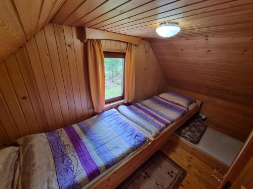 a small bed in a cabin with a window at Lodge In Koprivnik in Koprivnik v Bohinju