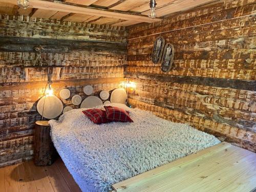 Un dormitorio con una cama en una pared de ladrillos. en La Cabane trappeur, en Gravières