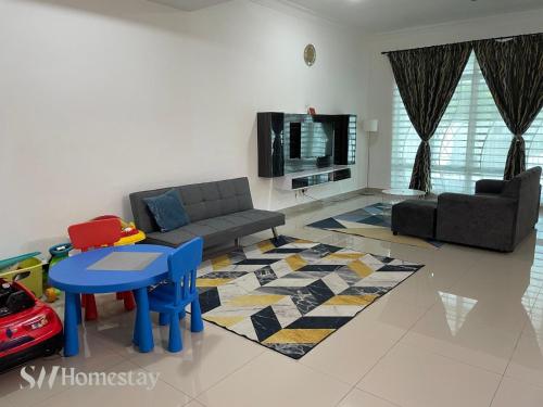 a living room with a couch and a table and a tv at SW Homestay Kota Warisan, Sepang in Sepang