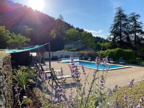 una piscina con flores púrpuras en el primer plano en La Cabane trappeur, en Gravières