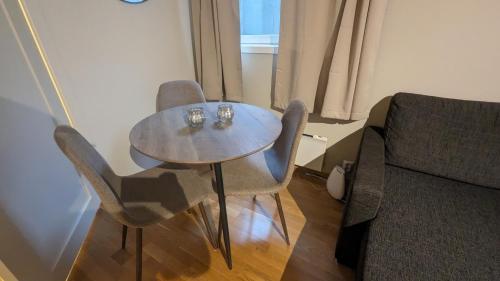 un tavolo e sedie in soggiorno con divano di Sjarmerende og sentral hybel med egen Inngang a Oslo