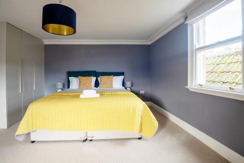 a bedroom with a bed with a yellow bedspread at Dream Stays Bath - Barton House in Bath