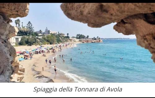 a group of people on a beach near the water at Perla marina in Avola