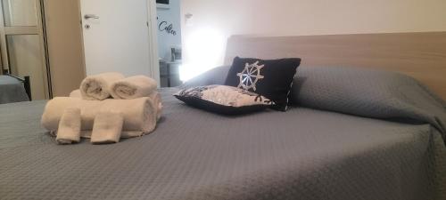 a bed with towels and pillows on it at Perla marina in Avola