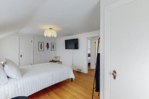 a white bedroom with a white bed and a television at The Perfect Pass-HOF Village Escape in Canton