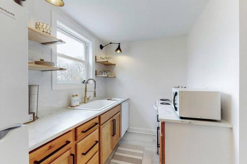 a white kitchen with a sink and a window at The Perfect Pass-HOF Village Escape in Canton